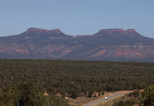 A vehicle rides on a highway past a pair of buttes known as the Bears Ears in Bears Ears National Monument outside Blanding, Utah, U.S., October 22, 2023. REUTERS/Jim Urquhart/File Photo