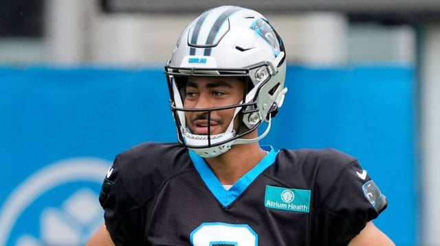 Carolina Panthers quarterback Bryce Young (9) and quarterback Andy Dalton (14) talk during training camp at Carolina Panthers Practice Fields.