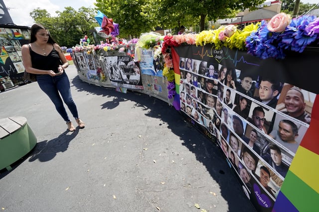 FILE - A visitor looks over a display with the photos and names of the 49 victims that died at the Pulse nightclub memorial, June 11, 2021, in Orlando, Fla. (AP Photo/John Raoux, file)