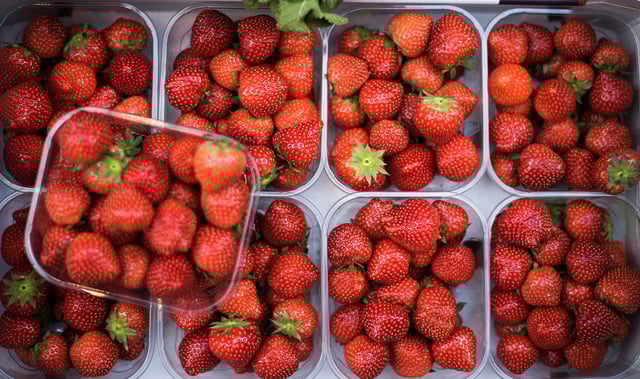 Red strawberry fruits seen at a market stall with copy space - stock photo