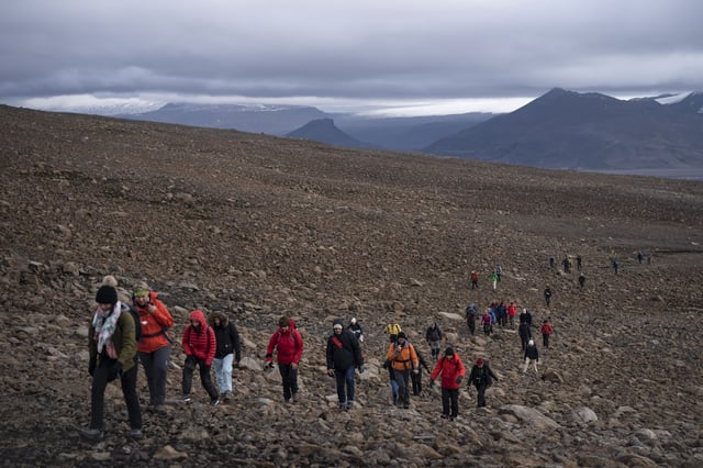 FILE - People climb to the top of what once was the Okjokull glacier, in Iceland, Aug. 18, 2019. (AP Photo/Felipe Dana, File)