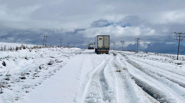 Lkw kommen auf einer schneebedeckten Fernstraße in Südafrika kaum voran.