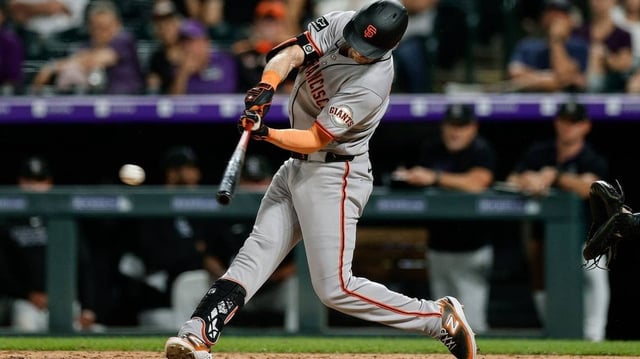 Jun 10, 2025; Denver, Colorado, USA; San Francisco Giants right fielder Mike Yastrzemski (5) hits an RBI single in the ninth inning against the Colorado Rockies at Coors Field. Mandatory Credit: Isaiah J. Downing-Imagn Images