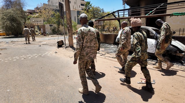 Members of the Sudanese army walk next to destroyed military vehicles after a battle with Rapid Support Forces (RSF) in the capital Khartoum, Sudan March 25, 2025. REUTERS/Stringer/File Photo