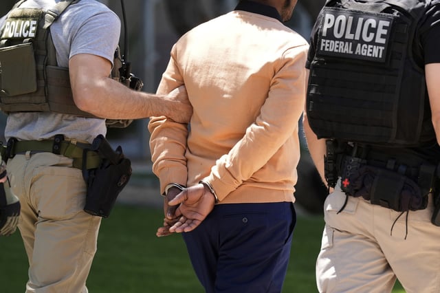 Federal agents take a person into custody after an immigration court hearing outside an immigration court, in Phoenix, on May 21, 2025.
