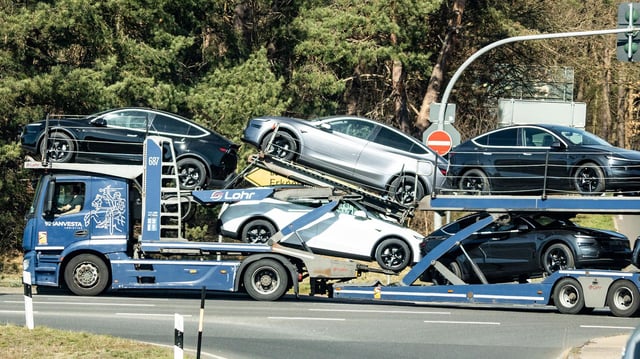 Ein voll beladener Autotransporter mit neuen Tesla-Fahrzeugen verlässt das Werksgelände nahe Grünheide.
