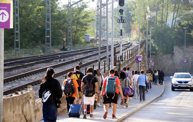 Viajeros del tren, en Centelles, se dirigen a la parada de bus para seguir su camino, durante el corte de la R3, en octubre de 2023