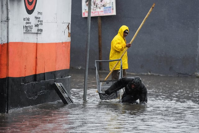 A man stumbles as he tries to cross a flooded road following severe weather with heavy rain from a cold front in Masiphumelele, Cape Town, South Africa on May 20, 2025. REUTERS/Nic Bothma