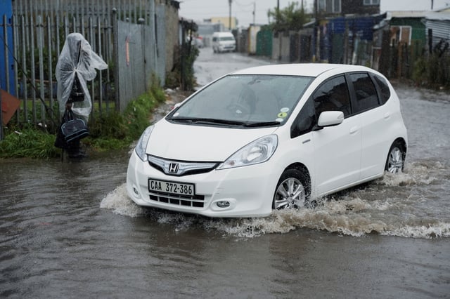 A vehicle drives along a flooded road following severe weather with heavy rain from a cold front in Masiphumelele, Cape Town, South Africa on May 20, 2025. REUTERS/Nic Bothma
