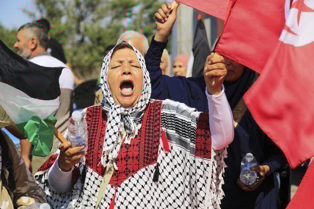 Members of a humanitarian convoy of at least 1,500 people, including activists and supporters from Algeria and Tunisia, shout pro-Palestinian slogans as they gather, on their way to Gaza via Egypt's Rafah Crossing, in Zawiya, Libya, Tuesday, June 10, 2025. (AP Photo/Yousef Murad)