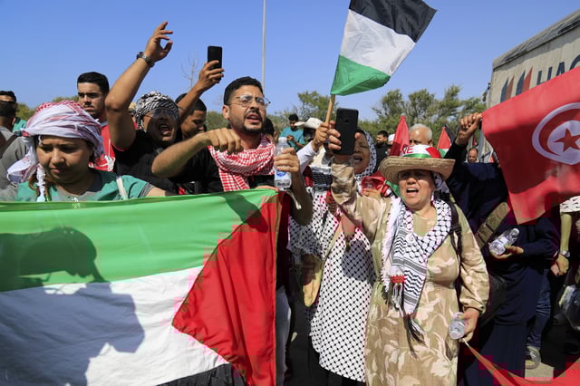 Members of a humanitarian convoy of at least 1,500 people, including activists and supporters from Algeria and Tunisia, shout pro-Palestinian slogans as they gather, on their way to Gaza via Egypt's Rafah Crossing, in Zawiya, Libya, Tuesday, June 10, 2025. (AP Photo/Yousef Murad)