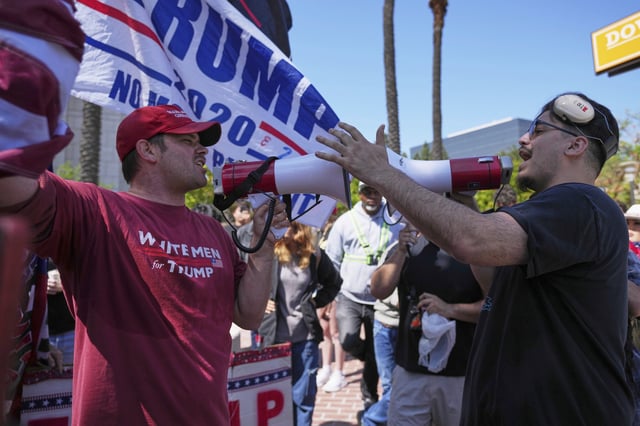 A protester wearing a shirt reading "WHITE MEN for TRUMP" argues with another protester Tuesday, June 10, 2025, in Santa Ana, Calif. (AP Photo/Jae C. Hong)