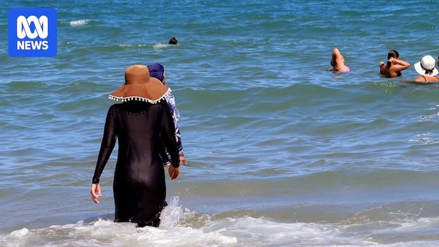 A woman wearing burkini enjoys the sea