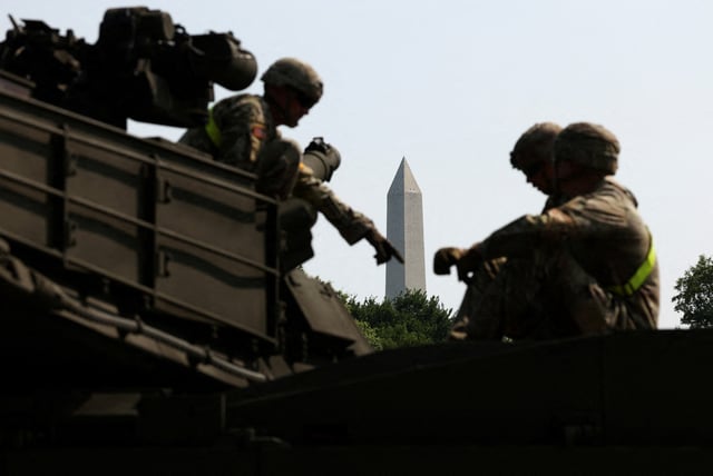 The Washington Monument is seen in the background as soldiers work on an M1A2/Abrams tank ahead of the upcoming U.S. Army 250th anniversary celebration parade in Washington, D.C., U.S., June 11, 2025. REUTERS/Kevin Lamarque
