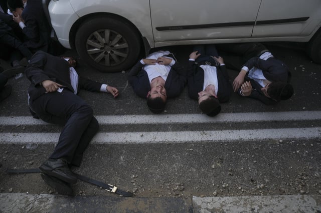 FILE - Ultra-Orthodox Jewish men block a highway during a protest against army recruitment in Bnei Brak, Israel, on March 2, 2025. (AP Photo/Ohad Zwigenberg, File)