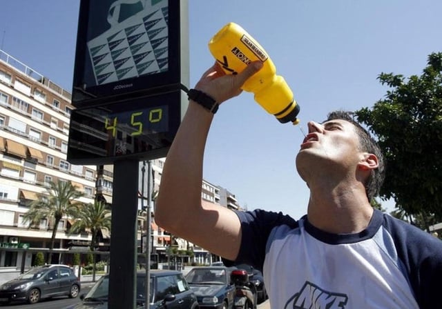 Un joven se refresca en una jornada de calor abrasador en Córdoba