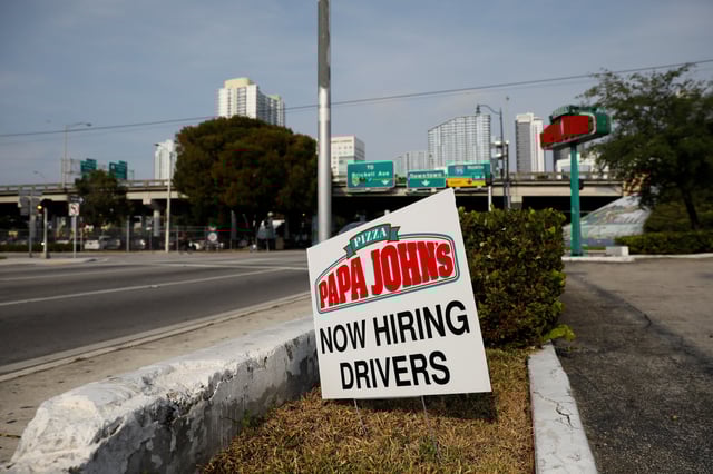A "Now Hiring" sign advertising jobs at Papa Johns is seen along a street in downtown Miami, Florida, U.S. April 13, 2020. REUTERS/Marco Bello/File Photo