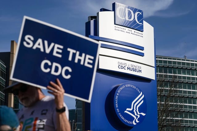 A man holds up a sign outside the main campus of the Centers For Disease Control and Prevention (CDC) on April 1, 2025 in Atlanta, Georgia.
