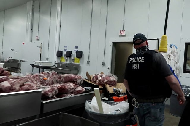An agent passes meat being prepared during a raid by U.S. Immigration and Customs Enforcement (ICE) at a Glenn Valley Foods meat production plant in Omaha, Nebraska, U.S. June 10, 2025 in a still image from video.  U.S. Immigration and Customs Enforcement/Handout via REUTERS