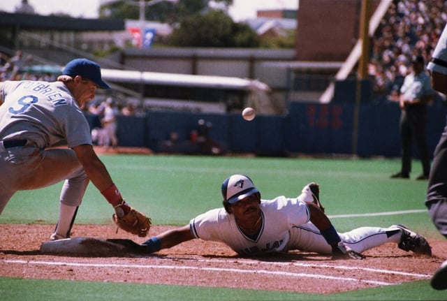 Blue Jays outfielder Jesse Barfield dives safely back to first base as the ball gets away from Texas Rangers first baseman Peter O'Brien in a game at Exhibition Stadium in Toronto on Saturday, Aug. 3, 1985. THE CANADIAN PRESS/Mike Blake