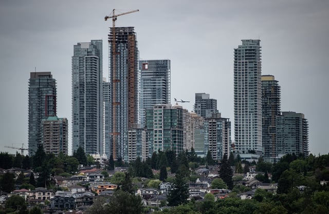 A plane passes behind condo towers in the Metrotown area of Burnaby, B.C., on Sunday, May 30, 2021. THE CANADIAN PRESS/Darryl Dyck