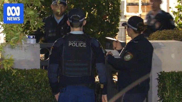A group of police officers stood outside a house