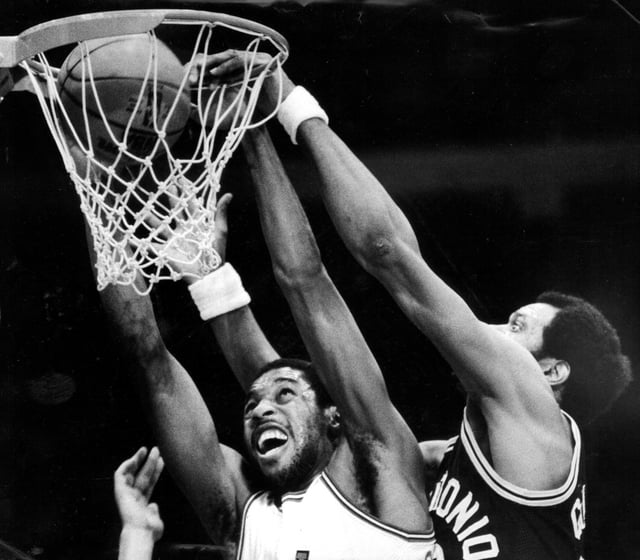 Bulls forward David Greenwood, left, dunks past Spurs center Artis Gilmore in 1982. (Phil Mascione/Chicago Tribune)