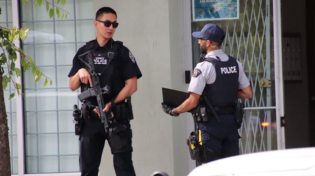 Surrey Police Service and RCMP officers outside a business in the 15900 block of 84th Avenue on Wednesday, June 11.