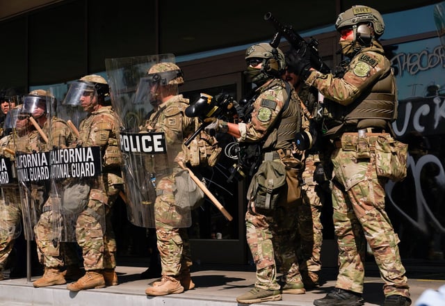 California National Guard troops stand guard as people attend a rally against federal immigration sweeps, in Los Angeles, California, U.S. June 9, 2025. REUTERS/David Ryder/File Photo