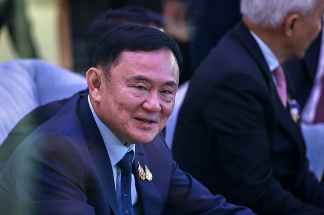 Former Thai Prime Minister Thaksin Shinawatra speaks with businessmen ahead of the "Vision for Thailand" event in Bangkok, Thailand, August 22, 2024. Picture taken through glass. REUTERS/Athit Perawongmetha/File Photo