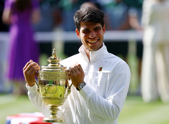 Tennis - Wimbledon - All England Lawn Tennis and Croquet Club, London, Britain - July 14, 2024 Spain's Carlos Alcaraz poses for a picture with the trophy after winning his men's singles final against Serbia's Novak Djokovic REUTERS/Hannah Mckay/File Photo