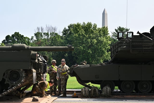 A U.S. soldier crawls out from under a M1 Abrams tank taking part in the Army&#39;s 250th birthday celebration parade during a preview at West Potomac Park in Washington, D.C., on June 11, 2025.