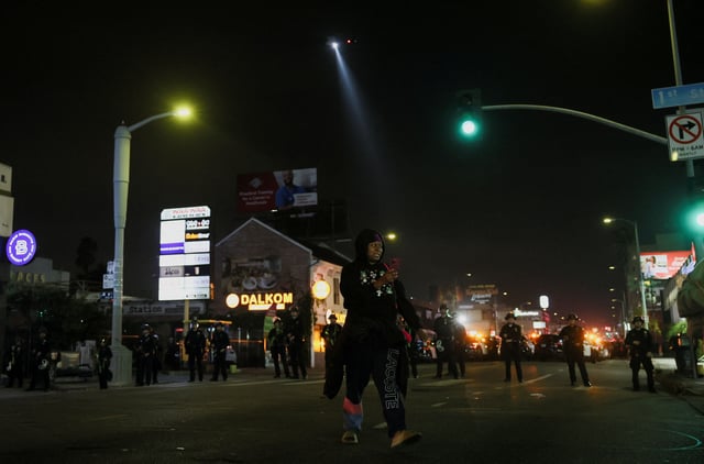 A local tries to get home, as law enforcement officers stand guard, on the day people march as part of the ongoing protests against Immigration and Customs Enforcement (ICE), in Los Angeles, California, U.S. June 11, 2025. REUTERS/Leah Millis