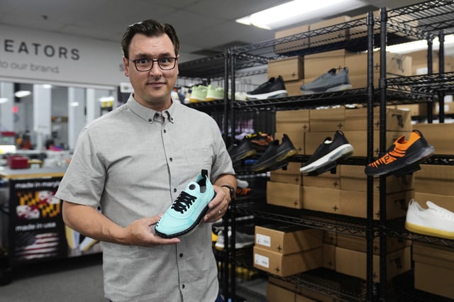 Alan Guyan, founder and CEO of Made Plus, holds a new colorway of the company's "bangr," a pickleball sneaker, at the company's manufacturing facility in Annapolis, Md., Tuesday, June 10, 2025. (AP Photo/Stephanie Scarbrough)