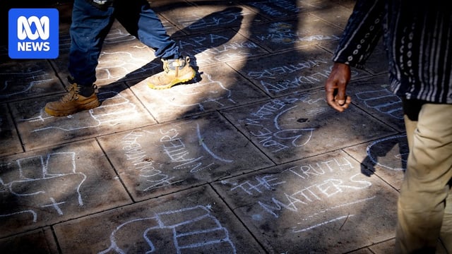 Chalk drawings on a footpath read "the truth matters" and "love matters".