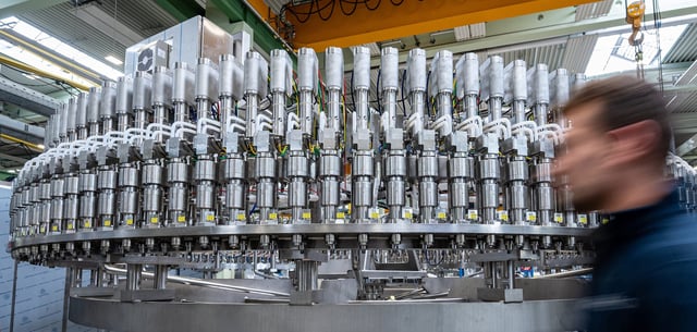 Ein Mitarbeiter geht an einer Abfüllanlage in der Produktion eines Maschinenbauunternehmens vorbei