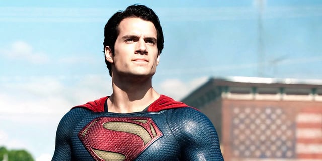 Superman (played by Henry Cavill), stands heroically in the streets of Smallville Kansas in Man of Steel.