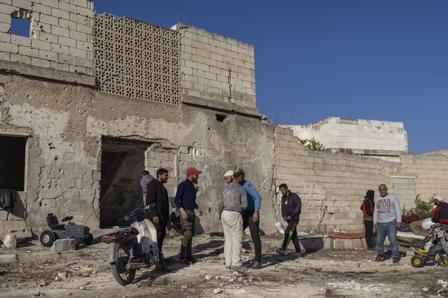 FILE - A family is greeted by locals after their return to their home, in a neighbourhood in Maarat al-Numan, on the outskirts of Idlib, Syria, Wednesday, Jan. 15, 2025. 