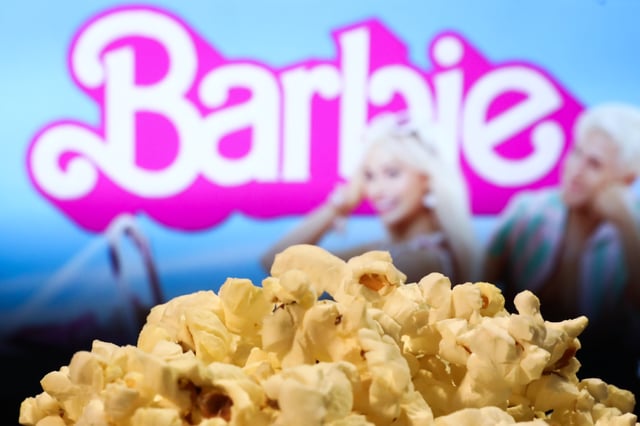 A popcorn and Barbie movie website displayed on a screen in the background are seen in this illustration photo taken in Krakow, Poland on August 1, 2023. (Photo by Jakub Porzycki/NurPhoto via Getty Images)