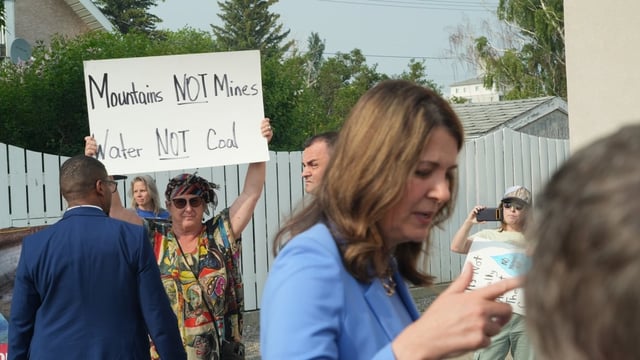 Alberta Premier Danielle Smith is challenged by protesters while speaking to reporters before a town hall on coal exploration in the eastern slopes of the Rocky Mountains, held in Fort MacLeod, Alta., on June 11, 2025.