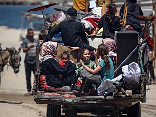 Palestinians carry their personal belongings as they flee northern Gaza toward Gaza's port amid Israeli evacuation orders and ongoing bombardment. (Photo by Majdi Fathi/NurPhoto)