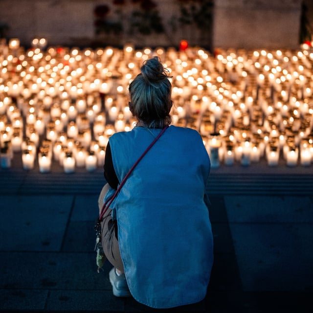 Menschen legen nach dem Amoklauf in einer Schule in Graz Kerzen vor dem Stephansdom in Wien nieder.