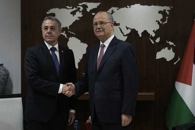 Swiss Federal Councillor Ignazio Cassis, left, shakes hands with Palestinian Prime Minister Mohammad Mustafa, right, in the West Bank city of Ramallah, Wednesday, June 11, 2025. (AP Photo/Majdi Mohammed)