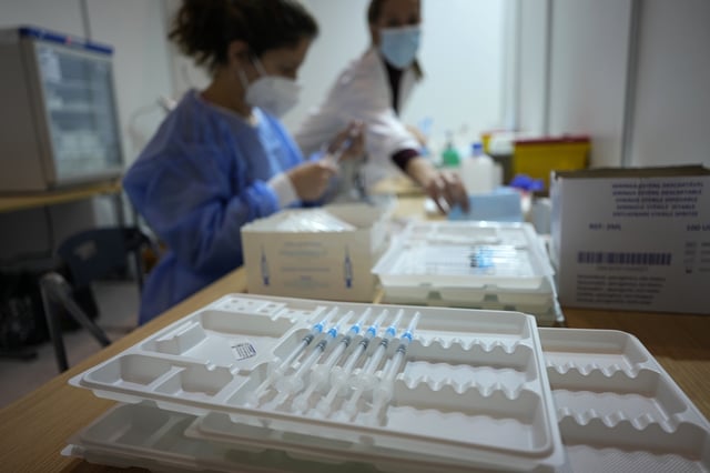 Nurses prepare doses of vaccines against COVID-19 on the first day of a new vaccination center in Lisbon, Wednesday, Dec. 1, 2021. Long lines formed at the Portuguese capital's largest vaccination center to date as authorities there tried to encourage the 2% of the population who are not vaccinated yet, Europe's lowest rate, and to speed up the administration of booster shots. Despite its excellent vaccination record, cases have been rising non-stop over the past two months, although hospitalizations are far away from levels seen in previous surges. (AP Photo/Armando Franca)