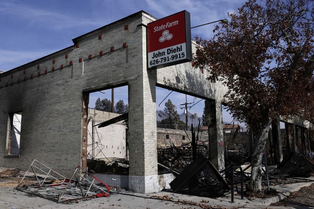 A State Farm sign hangs onto the remains of building destroyed by the Eaton Fire in Altadena in Los Angeles County on Feb. 3. The California Department of Insurance will look into customer complaints about State Farm&#39;s claims processing in the wake of the fires.