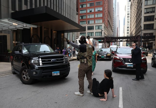 A federal agent exited the vehicle to move an activists who blocked the road outside of the Chicago Immigration Court at 55 East Monroe Street in Chicago, June 12, 2025.(Eileen T. Meslar/Chicago Tribune)