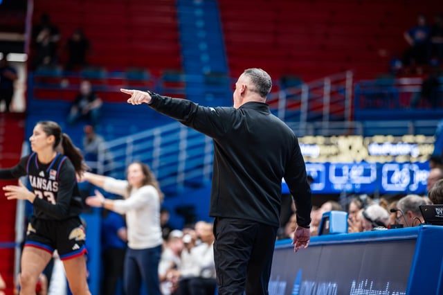 Kansas women's basketball coach Brandon Schneider coaches his players during a Dec. 15, 2024 game against Penn State in Lawrence, Kansas.