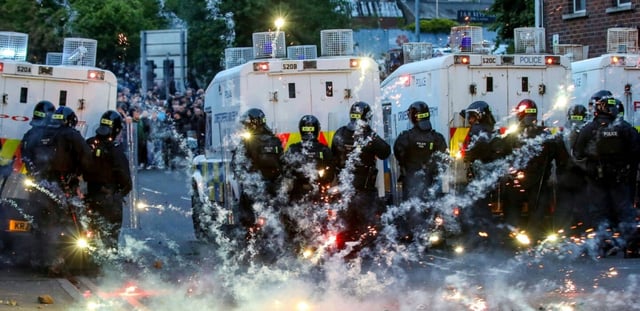 Des feux d'artifice lancés sur la police anti-émeute lors d'une troisième nuit de manifestations visant les immigrés à Ballymena, en Irlande du Nord, le 11 juin 2025