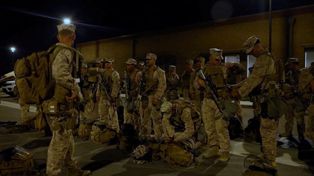 U.S. Marines stand with their packs and weapons, as protests against federal immigration sweeps continue, in greater Los Angeles, California, U.S., June 9, 2025, in this screen grab taken from a handout video. DVIDS/Handout via REUTERS/File Photo