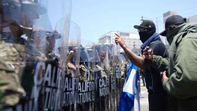 Protesters confront a line of U.S. National Guard in the metropolitan detention center of downtown Los Angeles, on Sunday, following the previous night's immigration raid protest. 